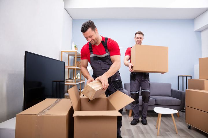 Movers packing boxes in a living room (Packing Services) by Moving Pros CLE