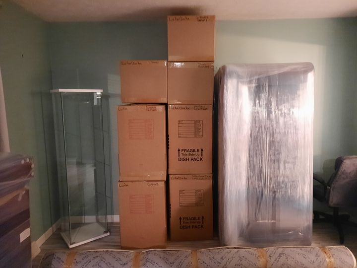 Packed boxes and a shrink-wrapped mirror (Packing services) by Moving Pros CLE